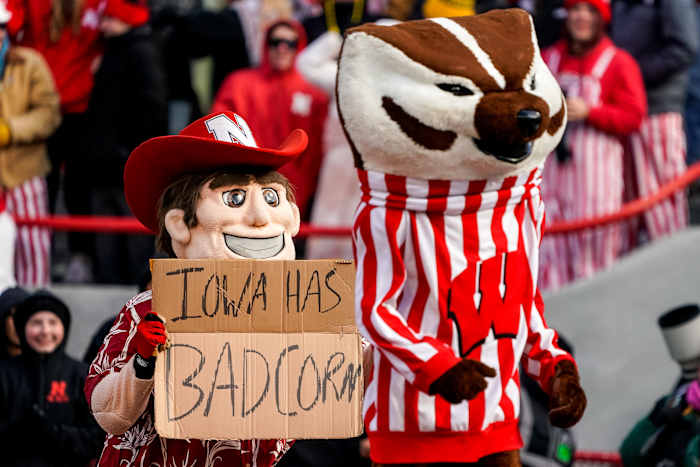 Nov 19, 2022; Lincoln, Nebraska, USA; Herbie Husker and Bucky Badger pose with a Iowa has bad corn sign during the game between the Nebraska Cornhuskers and the Wisconsin Badgers at Memorial Stadium. Mandatory Credit: Dylan Widger-USA TODAY Sports